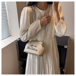 Détail du sac à main en paille avec broderie et bandoulière chaîne à billes dorées