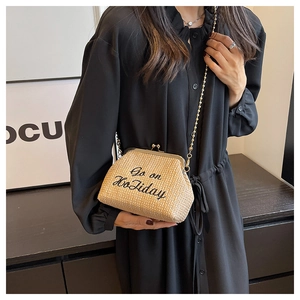 Vue détaillée de la pochette en paille avec broderie Go on Holiday et chaîne dorée