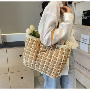 Détail du sac fourre-tout en paille tressée avec bandoulière en cuir marron