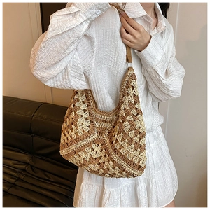 Detail of hand-woven crochet tote bag with contrast floral pattern and leather shoulder strap