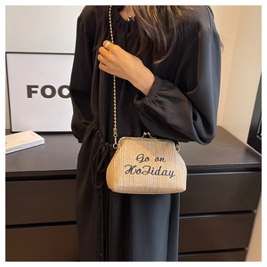 Détail du sac bandoulière en paille tissée avec broderie Go on Holiday et chaîne