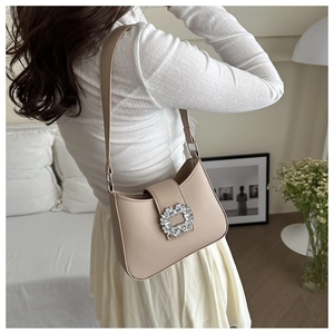 Detail of elegant milk tea PU leather handbag featuring a sparkling square crystal buckle