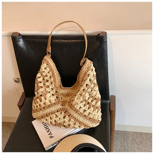 Macro detail of hand-woven straw tote with hollow pattern and premium leather shoulder strap