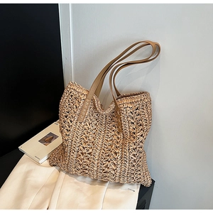 Fashionable woven straw tote bag with brown leather handles for summer travel