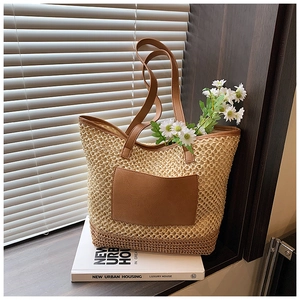 Stylish woven straw tote bag with brown leather pocket and handles for casual vacation look