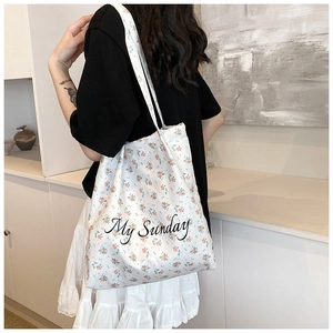 Rear view of model wearing white floral canvas tote bag with My Sunday print lettering