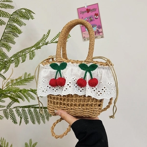 Handcrafted straw tote bag with white lace trim and cherry charms for summer outings