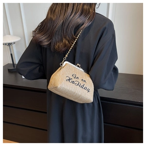 Détail du sac à main en paille beige avec broderie Go on Holiday et chaîne dorée