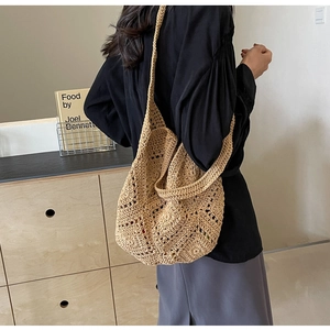 Détail d'un sac cabas en paille tissée avec motifs crochetés et large bandoulière chic
