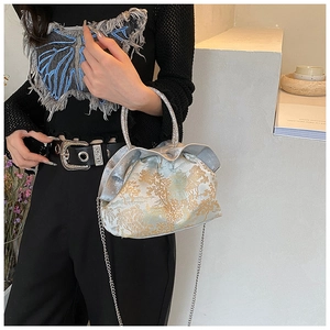 Detail of elegant jacquard crossbody bag with ruffled opening and rhinestone ring handle