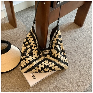 Close-up of contrast woven straw tote bag with geometric crochet pattern and leather strap