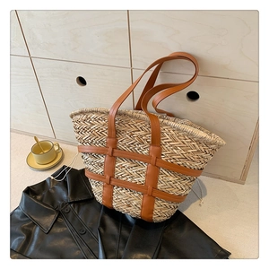 Fashionable straw tote bag with brown leather handles and woven herringbone pattern textures
