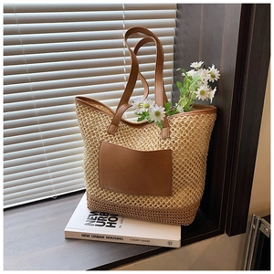 Straw woven tote bag with brown leather straps and pocket in a minimalist summer style