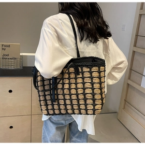 Détail du cabas en paille tissée à la main avec filet de corde noir et anses en similicuir
