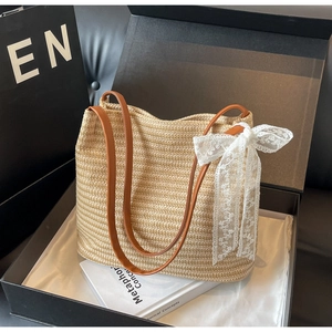 Sac à bandoulière chic en paille beige avec brides en cuir et grand nœud en dentelle