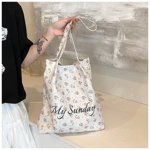 Detail view of a white floral canvas tote bag featuring My Sunday script typography
