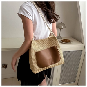 Vue détaillée du sac cabas en paille avec poche contrastée en cuir marron