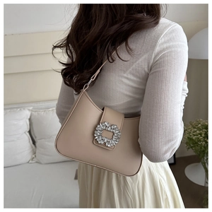 Detail of beige PU leather shoulder bag featuring a large square rhinestone buckle