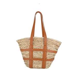 Summer woven straw tote bag with brown leather handles and a minimalist trapezoid shape