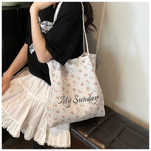Detail view of floral canvas tote bag featuring My Sunday text and orange floral print