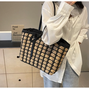 Détail d'un sac cabas en paille tissé à la main avec grille noire et cuir chic