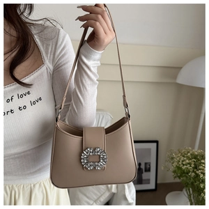 Detail shot of the beige PU leather shoulder bag featuring a sparkling crystal buckle