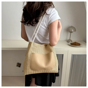 Détail du sac cabas en paille tressée avec poche en cuir kaki et bandoulière en corde