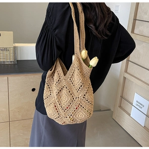 Gros plan du sac fourre-tout en crochet beige avec motifs ajourés et style bohème