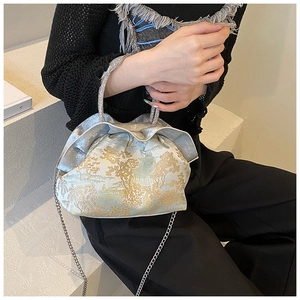 Close-up of cloud-shaped PU bag featuring golden embroidery and crystal handle