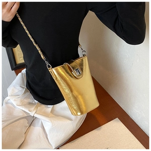 Dettaglio borsa a secchiello in pelle PU dorata con tracolla a catena e serratura