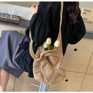 Vue détaillée du sac à main tricoté beige montrant le motif de losanges et la bandoulière