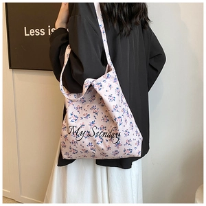 Floral canvas tote bag with My Sunday print shown on shoulder of a model