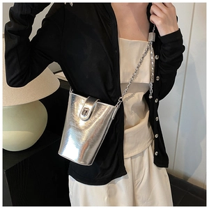 Dettaglio di una mini borsa a secchiello argento metallizzato con tracolla a catena