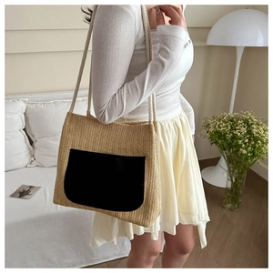 Sac fourre-tout en paille avec poche noire et anses en chanvre dans un décor chic et épuré