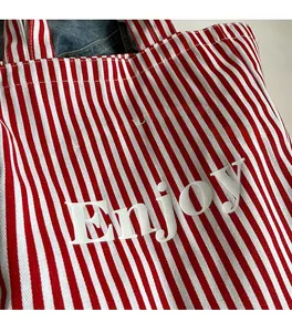 Detailed view of red and white striped canvas tote with star print and textured fabric