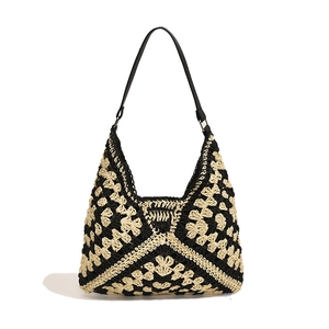 Handcrafted crochet tote bag with black and beige floral patterns and thin shoulder strap