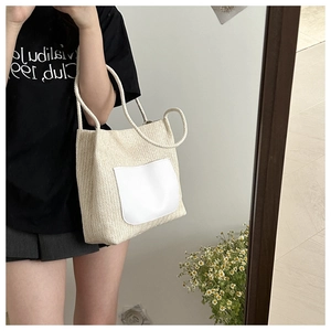 Détail du sac cabas en paille tissée avec poche en cuir blanc et anse en corde