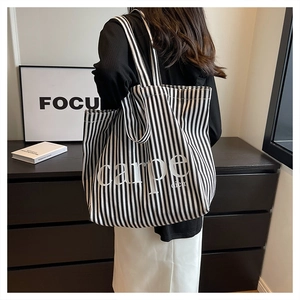 Detail view of large canvas tote bag with black and white stripes and Carpe Diem print
