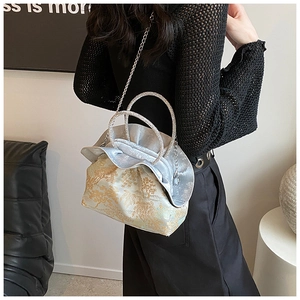 Detail of PU leather bag with rhinestone circular handles and elegant jacquard pattern