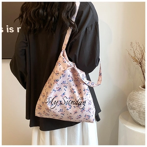 Detail of pink floral canvas tote bag featuring My Sunday script text and wide strap