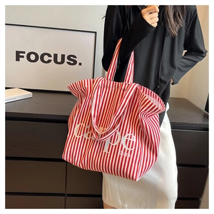 Detail of red and white striped canvas tote bag with Carpe Diem typography print
