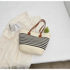 Minimalist woven tote bag with black stripes and brown leather straps for daily use