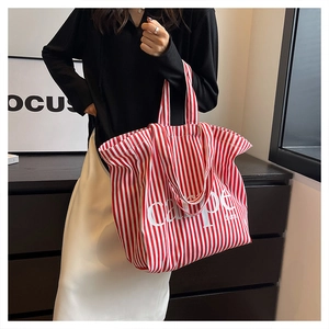 Detail of red and white striped canvas tote bag with carpe diem print for women