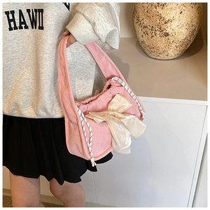 Detail of pink corduroy handbag with cream organza bow and black white rope drawstring