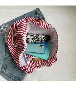 Interior view showing the large capacity of the striped canvas tote bag with magnetic clasp