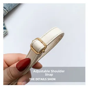Detail view of cream leather adjustable shoulder strap with golden metal buckle and stitching