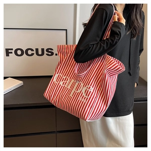 Detailed view of red and white striped canvas tote bag with Carpe Diem text