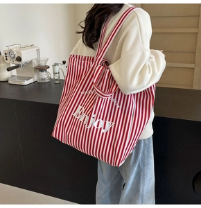 Detailed texture of red and white striped canvas tote bag with Enjoy slogan print