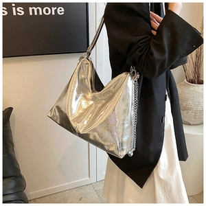 Close-up of silver metallic PU leather tote bag with chain detail and soft hobo shape