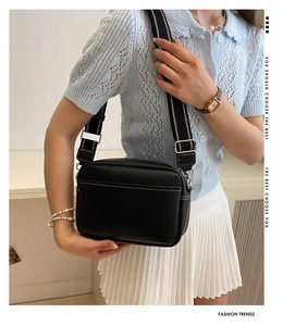 Minimalist black camera bag with black and white striped wide fabric strap for women